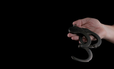 Obraz premium steel handcuffs of police special equipment, fetters on a black background