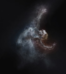 Fototapeta na wymiar Dancer from smoke on the dark background