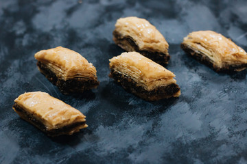 Baklava sweet dessert on wooden board. Pastry made of layers of filo filled with chopped nuts and...