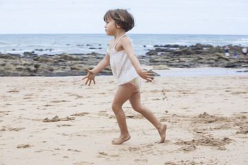 little girl running on a beach
