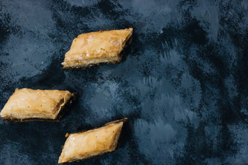 Baklava sweet dessert on wooden board. Pastry made of layers of filo filled with chopped nuts and...