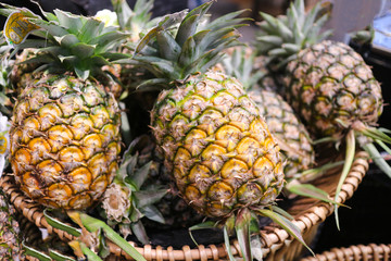 Group of pineapple on the basket in the gourmet market waiting for sell to customer.