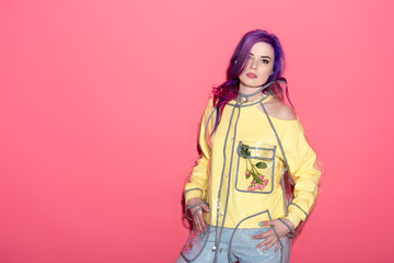 fashionable young woman in transparent raincoat on red