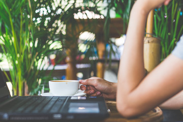 Human hands of a business working on laptop whit coffee cup