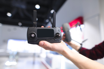 Remote control quadcopter in the hands of a man in the background of the store