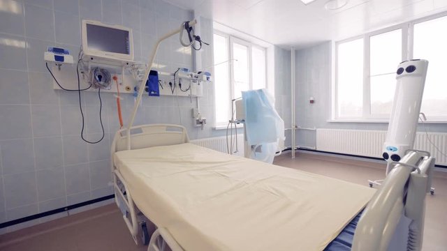 General view of a hospital room with a single bed and modern medical equipment.