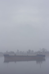 Fototapeta premium Ship on the IJssel river near Wilsum during a early sunny and misty morning.