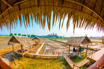 Fototapeta na wymiar View behind of Wat Thum Sua or Tiger Cave Temple on the mountain with wood bride cross the meadow at kanchanaburi province , thailand
