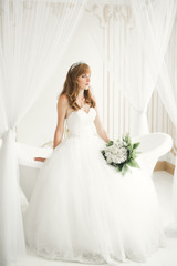 Fototapeta premium Gorgeous bride in robe posing and preparing for the wedding ceremony face in a room