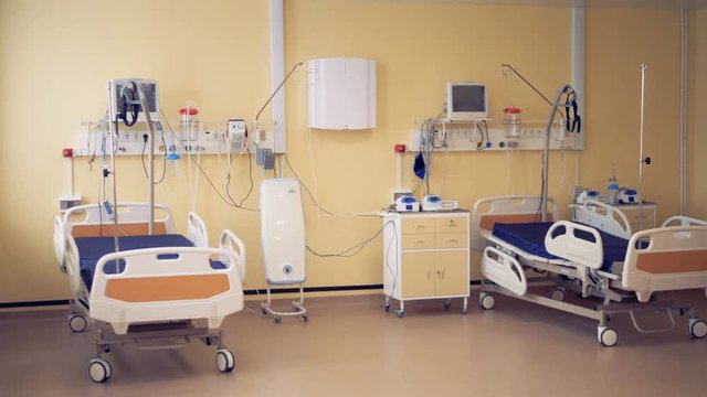 Two wheeled beds are standing in a fully-equipped hospital room