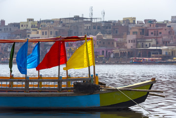 Fototapeta na wymiar Colored wooden boats with flags in Mathura, India