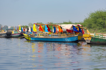 Colored wooden boats with flags in Mathura, India