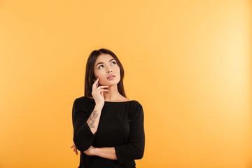 Thoughtful young woman standing isolated