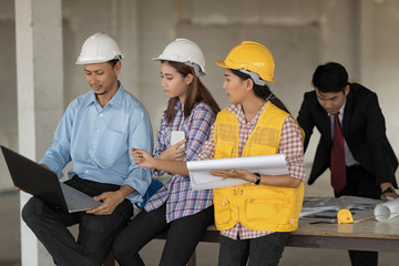 Colleagues Teamwork and equipment such as blueprint and technology laptop on the table.Industrial and teamworks Concept.