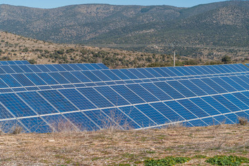 A row of rectangular solar panels on a solar panel field in central Spain