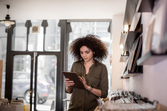 Small business owner using digital tablet in a record store