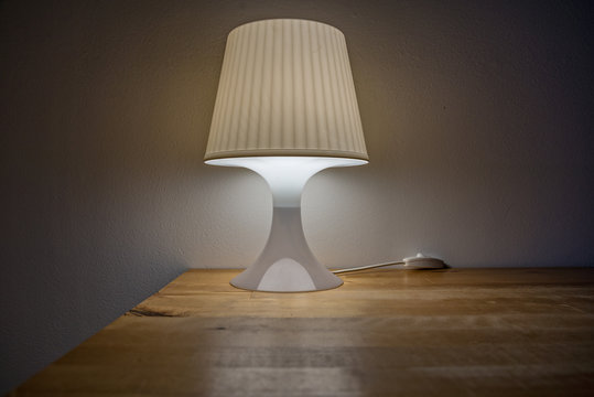 A Turn On Bedside Lamp Is On The Table