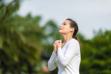 Beautiful woman in white clothing relaxing and praying in tha park.
