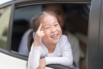 Happy woman with little child driving in car.