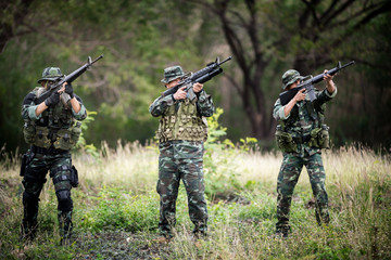 Squad of soldiers patrolling across the forest area.