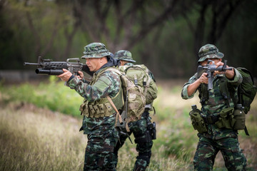 Fototapeta premium Squad of soldiers patrolling across the forest area.