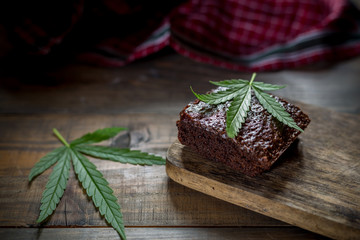 marijuana leaf on a marijuana brownie on wooden table