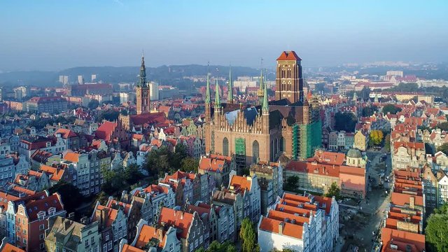 Gdansk, Poland. Aerial  4K reveal video of old city, and famous monuments: Gothic St Mary church, city hall tower, the oldest medieval port crane (Zuraw) in Europe, old houses and Motlawa river