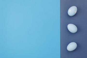 Top view shot of arrangement decoration Happy Easter holiday background concept.Flat lay beautiful of colorful bunny eggs on modern rustic bold duo tone blue paper office desk.Design pastel tone.