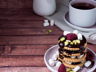 A sweet dessert of chocolate biscuit, raspberry marshmallow and a Cup of coffee on dark background.