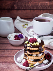 A sweet dessert of chocolate biscuit, raspberry marshmallow and a Cup of coffee on dark background.