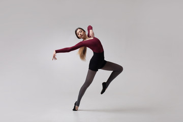 Fototapeta na wymiar young woman dancer in maroon swimsuit posing
