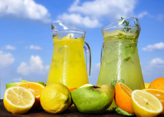 Light cocktails - orange-lemon and lemon-apple on a blue sky background