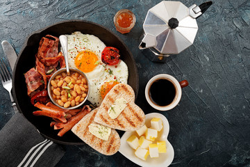 Full english breakfast with egg, sausage and bacon. top view