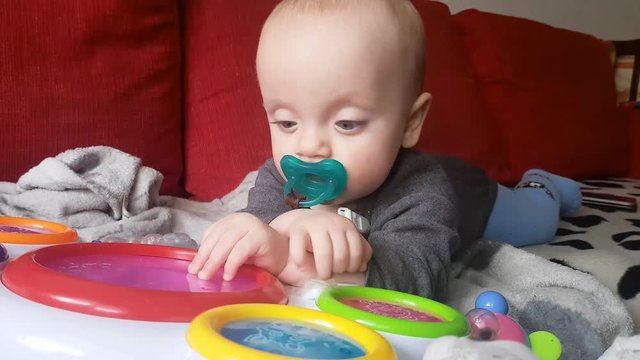 white baby boy playing musical toy drums