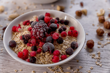 Oatmeal, nuts, woody fruit on a wooden background, ingredients, healthy food