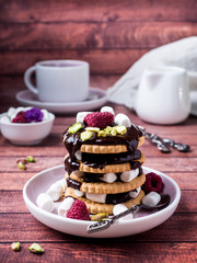 A sweet dessert of chocolate biscuit, raspberry marshmallow and a Cup of coffee on dark background.