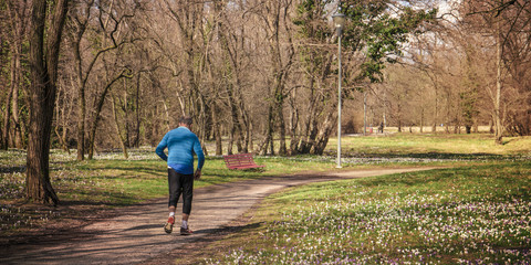 old man with blue jacket jogging at the park, sport in the nature concept
