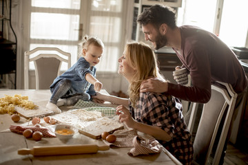Happy family making pasta in the kitchen at home
