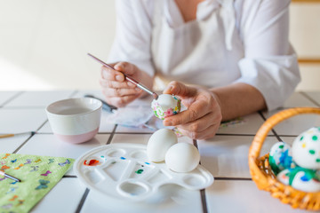 Woman decorating eggs with decoupage technique  