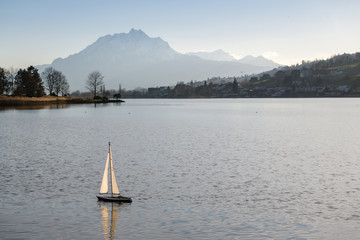 Obraz premium Small radio controlled boat on lake with Mount Pilatus in background