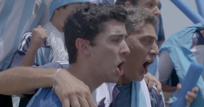Argentinian football supporters cheering at match, slow motion