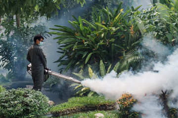 Man work fogging to eliminate mosquito for preventing spread dengue fever and zika virus
