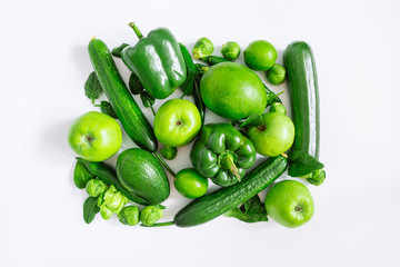 green vegetables and fruits on white background. overhead view