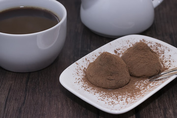 Dessert truffle on white plate. Soft focus.