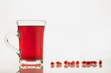 glass of garnet juice and grain on a white background/glass of garnet juice and grain on a white background. Copy space