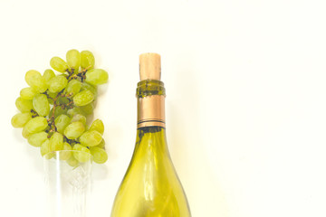 bottle of wine and a glass with a white grape brush on a white background