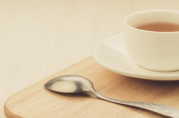 white cup of tea and spoon on a wooden traywhite cup of tea and spoon on a wooden tray. Copy space. selective focus