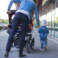 A little girl in jeans wear shows on the street