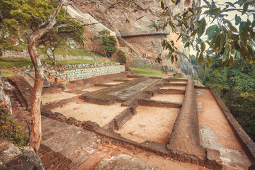 Tourists descending from the mountain in ancient Sigiriya city with ruins and archeological area
