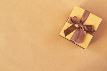 Golden gift box on wrapping paper background with copy space